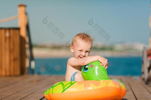 漂亮的小的男孩演奏和生活浮标在指已提到的人海滨