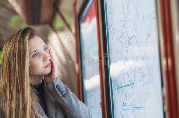 困恼的女人有样子的在火车交通工具的运行时间表