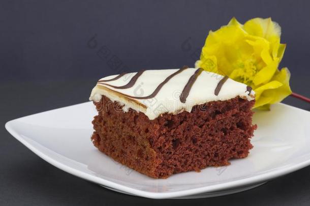 冰冷的红色的丝绒蛋糕向白色的大浅盘带腔调的和黄色的