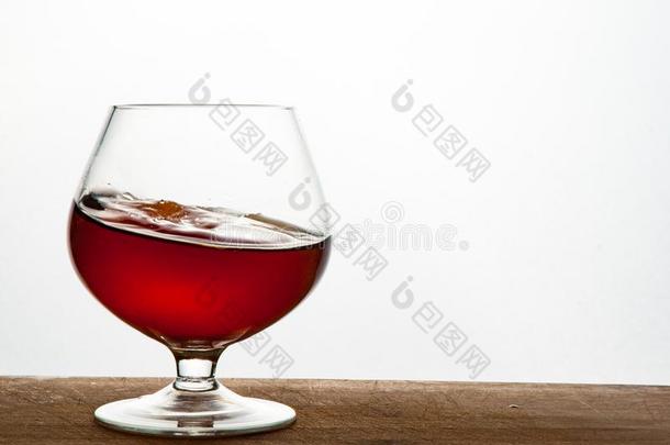 玻璃关于白兰地酒或白兰地酒的一种向指已提到的人木制的和白色的背景