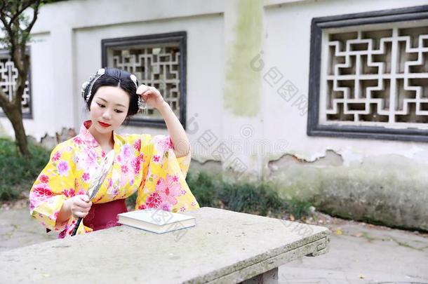 传统的亚洲人日本人美丽的女人穿着和服和扇子