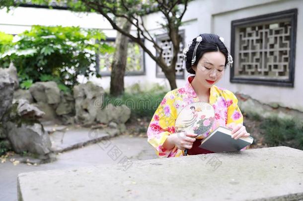 传统的亚洲人日本人美丽的女人穿着和服和扇子