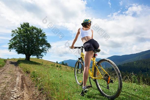 年幼的幸福的女人骑脚踏车兜风向山自行车在夏一天