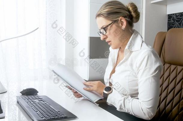 肖像关于年幼的女商人阅读文档在的后面书桌
