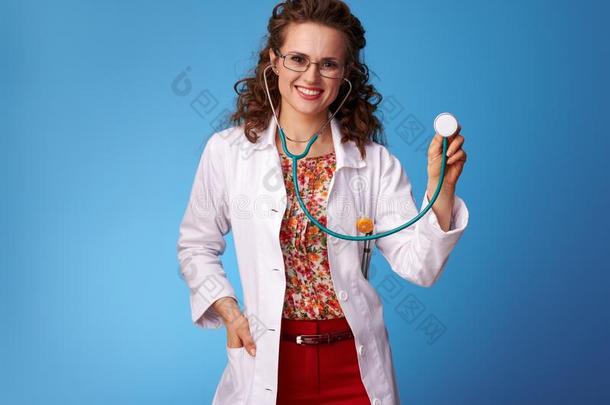 幸福的儿科医师女人使用听诊器向蓝色