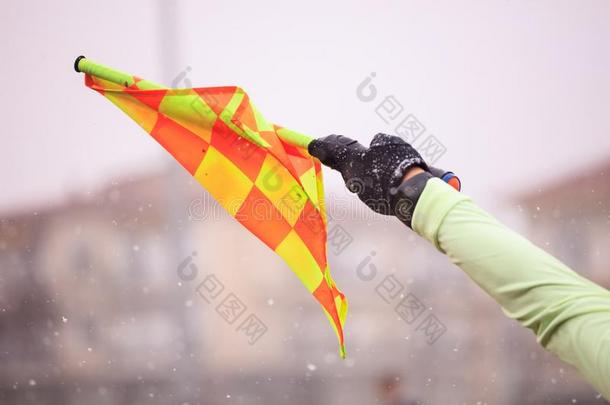 足球足球裁判员助手举起指已提到的人旗.变模糊下雪的