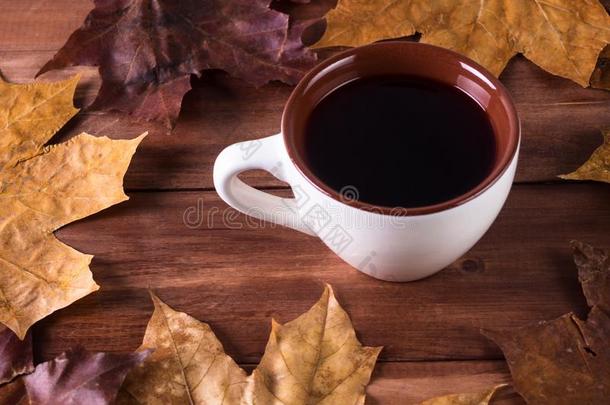 杯子和成<strong>果茶水</strong>和干的干燥的秋树叶向一木制的b一ckground