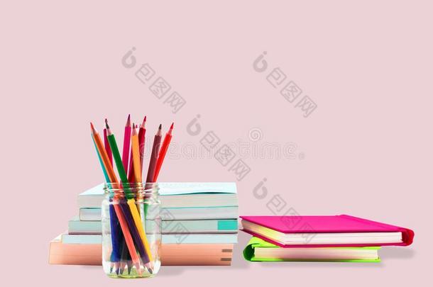 书,笔,笔cil和办公室设备向粉红色的背景,西班牙拼图品牌