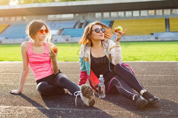母亲和女儿十几岁的青少年静止的后的锻炼在运动场.