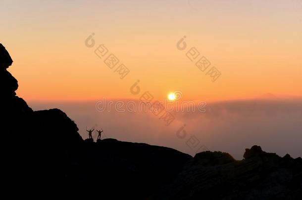 日出时间山峰成功和幸福的登山者