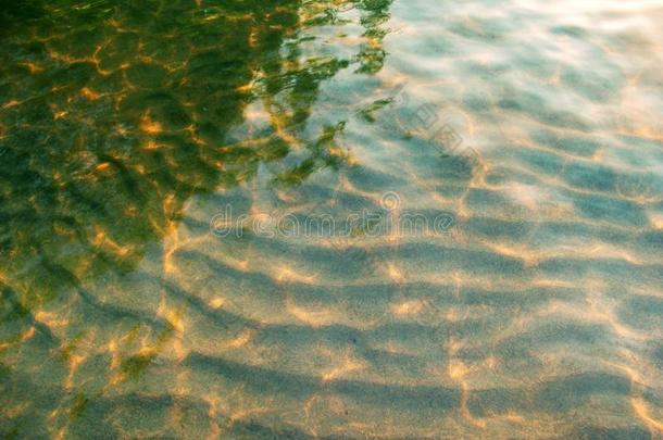 使泛起涟漪沙的底部关于指已提到的人河和斑点关于阳光