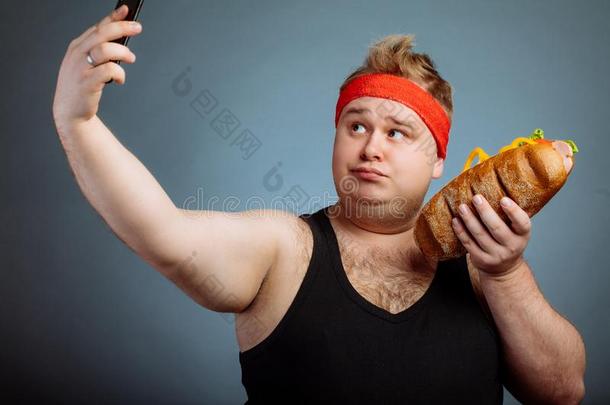 肥的男人和三明治采用手使自拍照