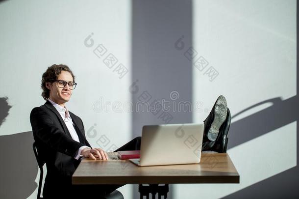 男人<strong>遵守</strong>木头支架向表和工作的向便携式电脑采用办公室