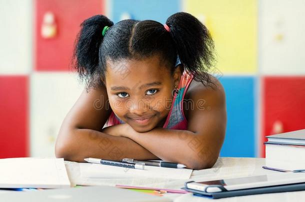 单调沉闷的小的非洲的学生一次在书桌采用教室.