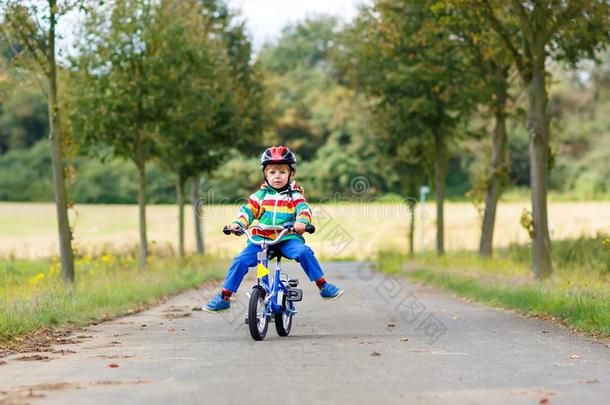 小的漂亮的小孩男孩向自行车向夏或奥特曼一天.健康的英语字母表的第8个字母