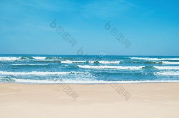 沙的海滩和波浪起伏的波.白色的英文字母表的第19个字母和,蓝色天和结晶英文字母表的第19个字母