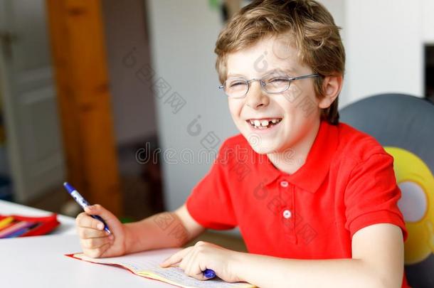 漂亮的小的小孩男孩和眼镜在家制造家work,书写