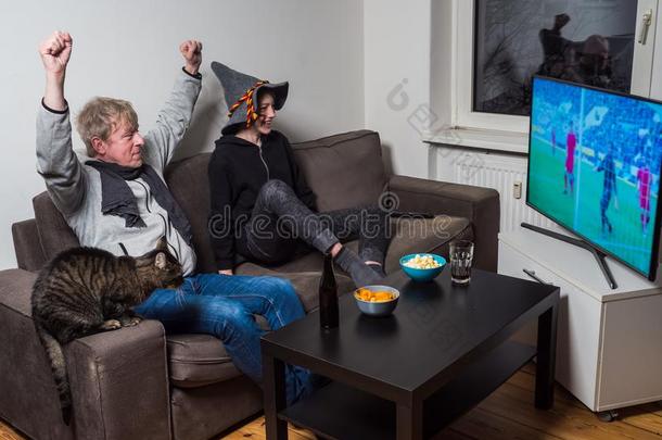 父亲,儿子和猫观察足球世界杯子足球向television电视机