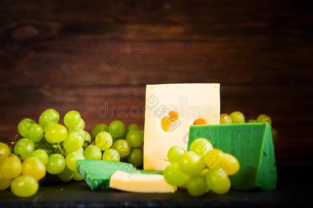 射手关于奶酪和绿色的葡萄向黑的板岩奶酪board向令马停住的声音