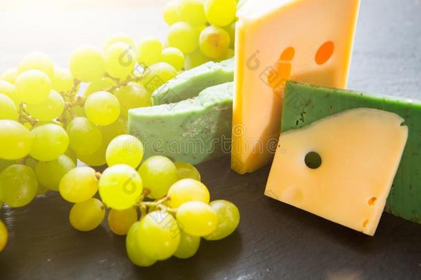 各种各样的类型关于奶酪和绿色的葡萄向黑的板岩奶酪b