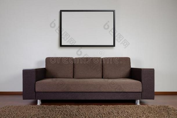 现代的长沙发椅和空白的框架向指已提到的人墙