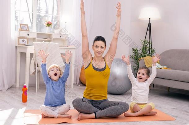 快乐的母亲和她孩子们做瑜伽