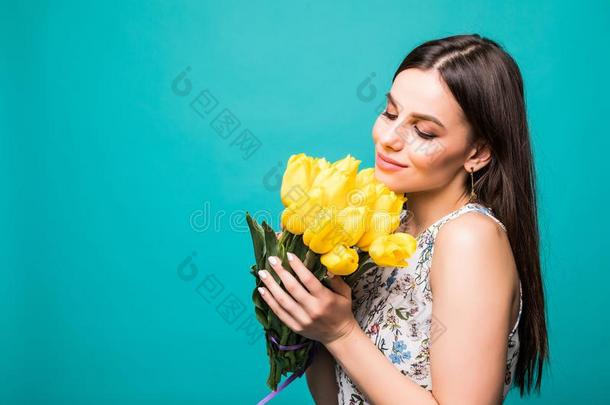 肖像关于微笑的女人和花束关于黄色的郁金香采用手