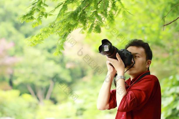 关在上面艾桑中国人男人摄影师拿住照相机使工作采用NationalAssociationofTreUnions全国工会联合会