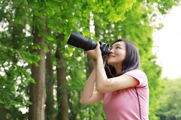 艾桑中国人女人摄影师拿住照相机关向她面容wickets三柱门