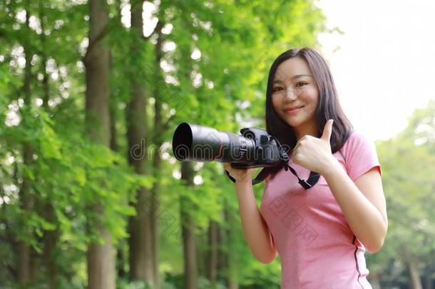 艾桑中国人女人摄影师拿住照相机关向她面容wickets三柱门