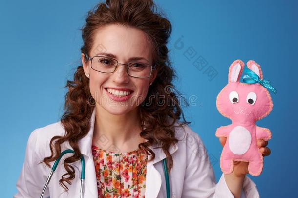 微笑的小儿科医师医生展映玩具向蓝色