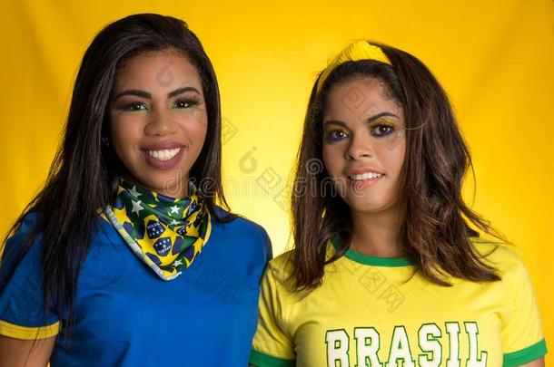 两个巴西人朋友庆祝向足球/足球比赛向