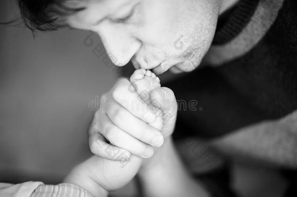 父亲接吻的脚关于新生的婴儿.