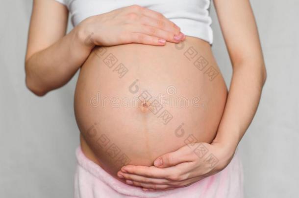 怀孕的女孩温柔地热烈地拥抱她肚子