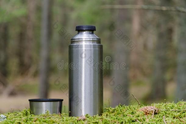 热水瓶和杯子向一长满苔藓的地面
