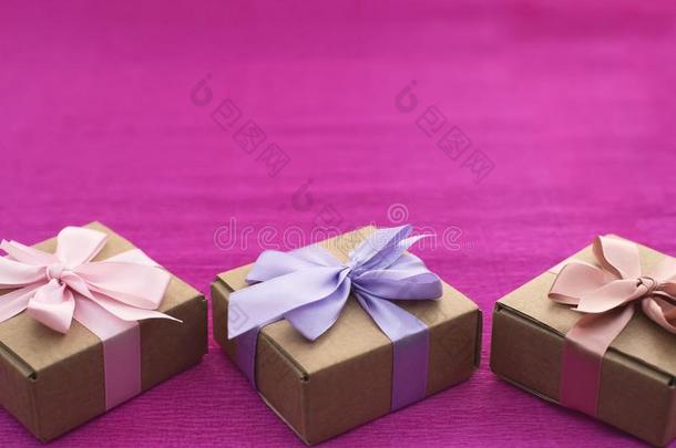 节日的作品num.三牛皮纸盒和礼物向明亮的粉红色的