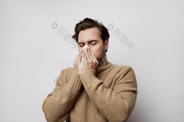 肖像不好的男人使人疲乏的毛织运动衫咳嗽起立空的后台