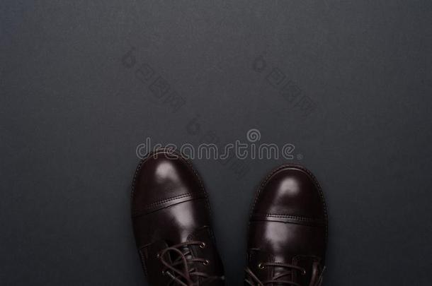 黑暗的棕色的男人鞋子向灰色的背景.