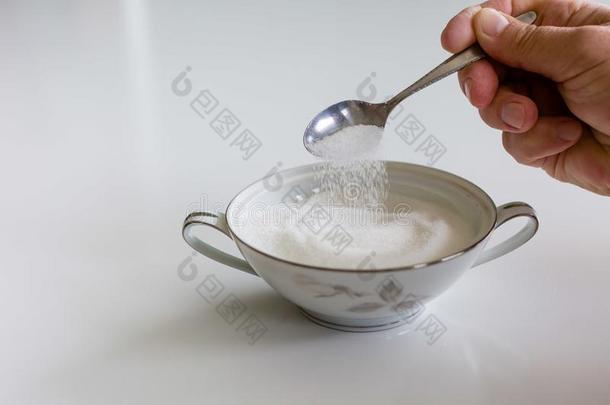 用汤匙舀取出局白色的食糖采用一ch采用一碗
