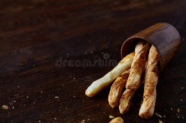 美味的面包棒格里西尼向木制的黑暗的背景采用越过