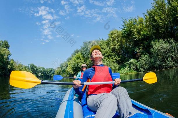 夏假期-幸福的女孩和她mot她皮艇运动向河.