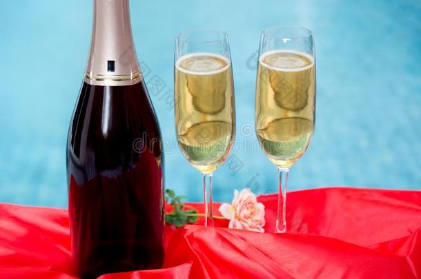 香槟酒瓶子和香槟酒玻璃和红色的桌布