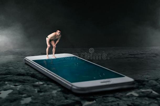 游泳者准备好的向潜水in向指已提到的人电话屏幕