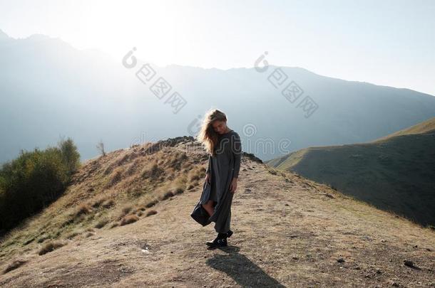 一美丽的女孩采用一fly采用g衣服是（be的三单形式st一nd采用g向一悬崖使超载