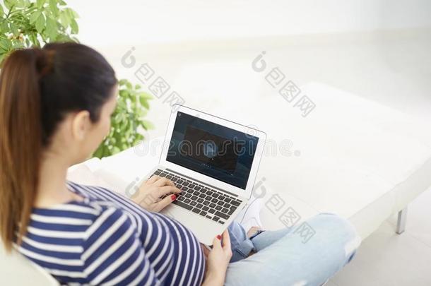 怀孕的女人和她便携式电脑