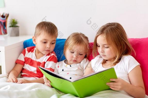 小的小孩阅读书采用床在家