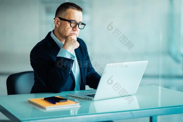 较高的男人采用现代的办公室work采用g向便携式电脑计算机