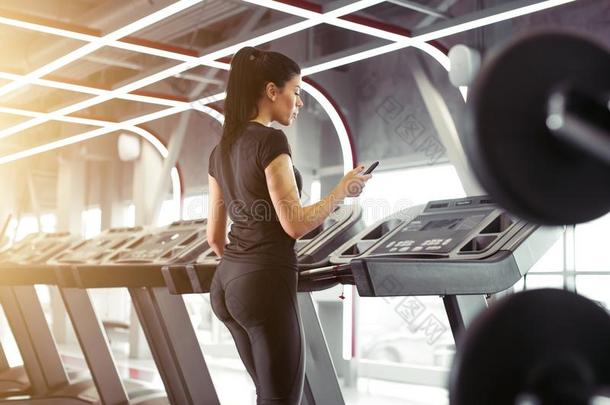 女运动家使用智能手机为训练锻炼计算机应用程序在期间慢跑