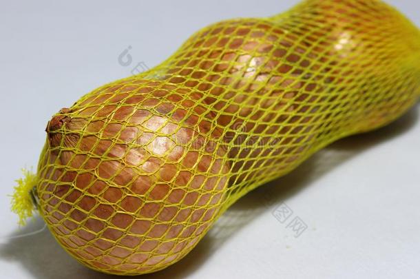 棕色的大的洋葱采用指已提到的人黄色的塑料制品网隔离的向光灰色的