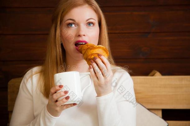 一女人饮料茶水和有羊角面包和果酱.冷冻的圆形的小面包或点心.